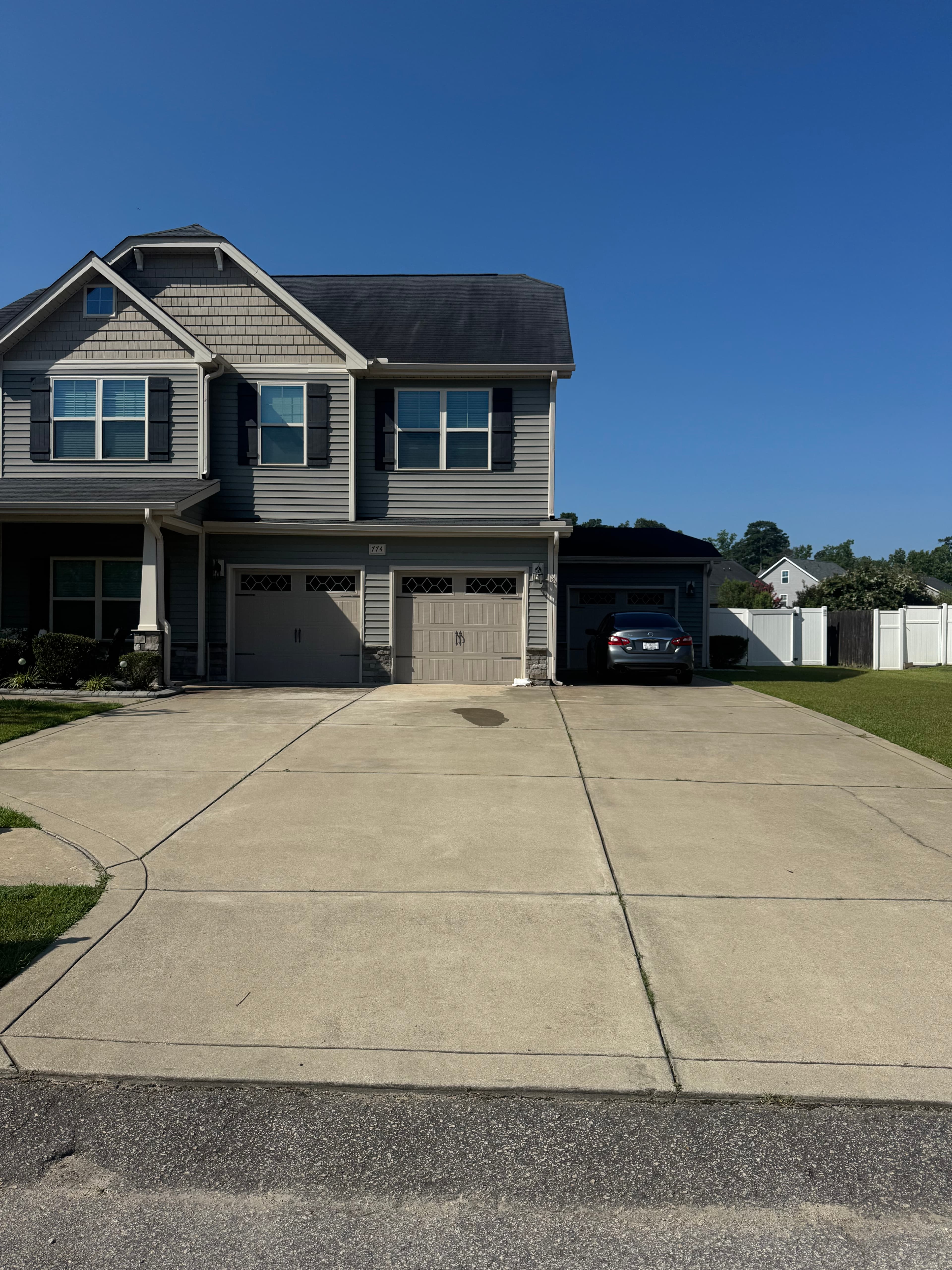 Before driveway pressure washing in Fayetteville NC — stained concrete with algae and dirt buildup