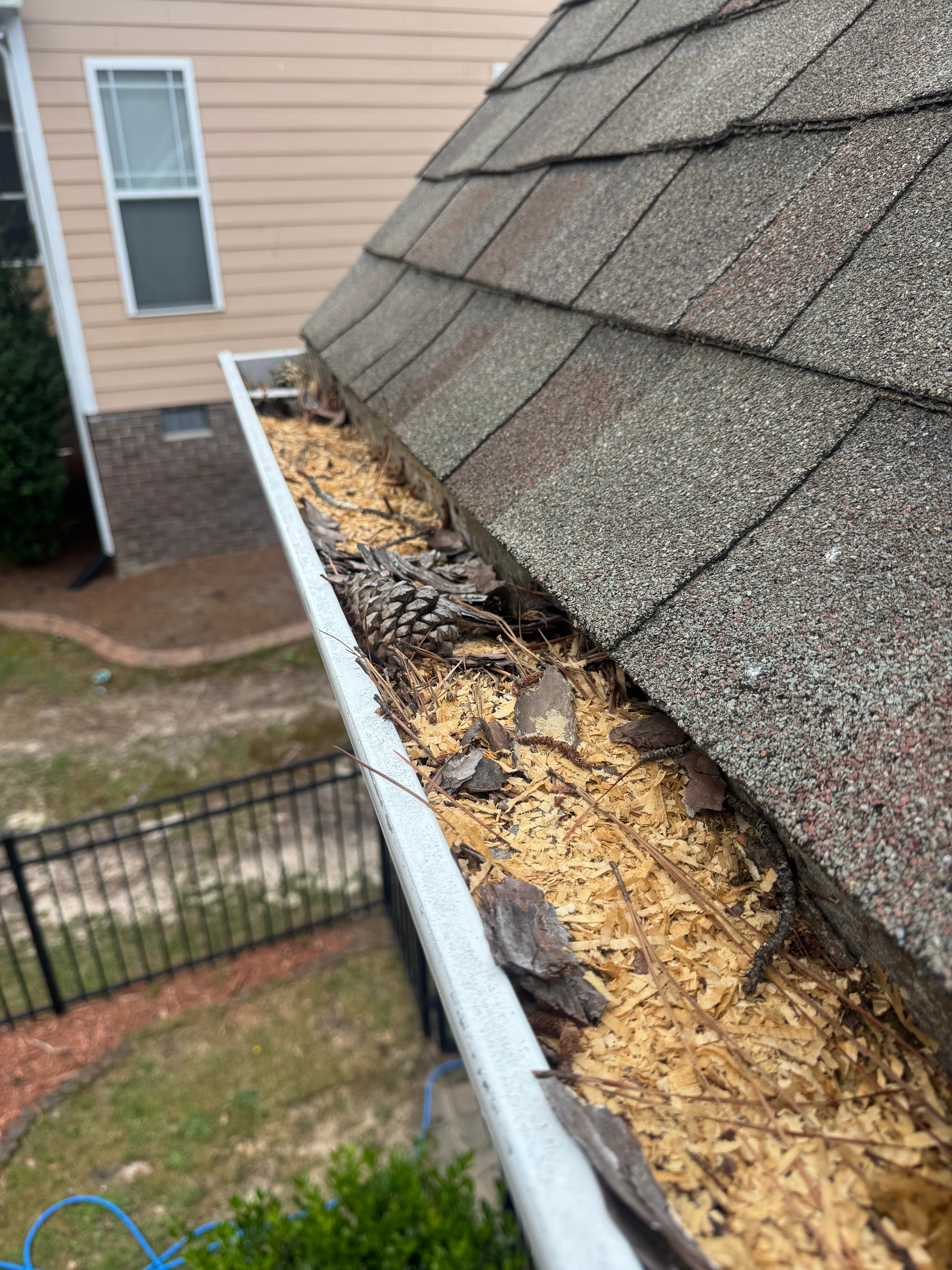 Before gutter cleaning in Fayetteville NC — gutters packed with leaves and pine straw