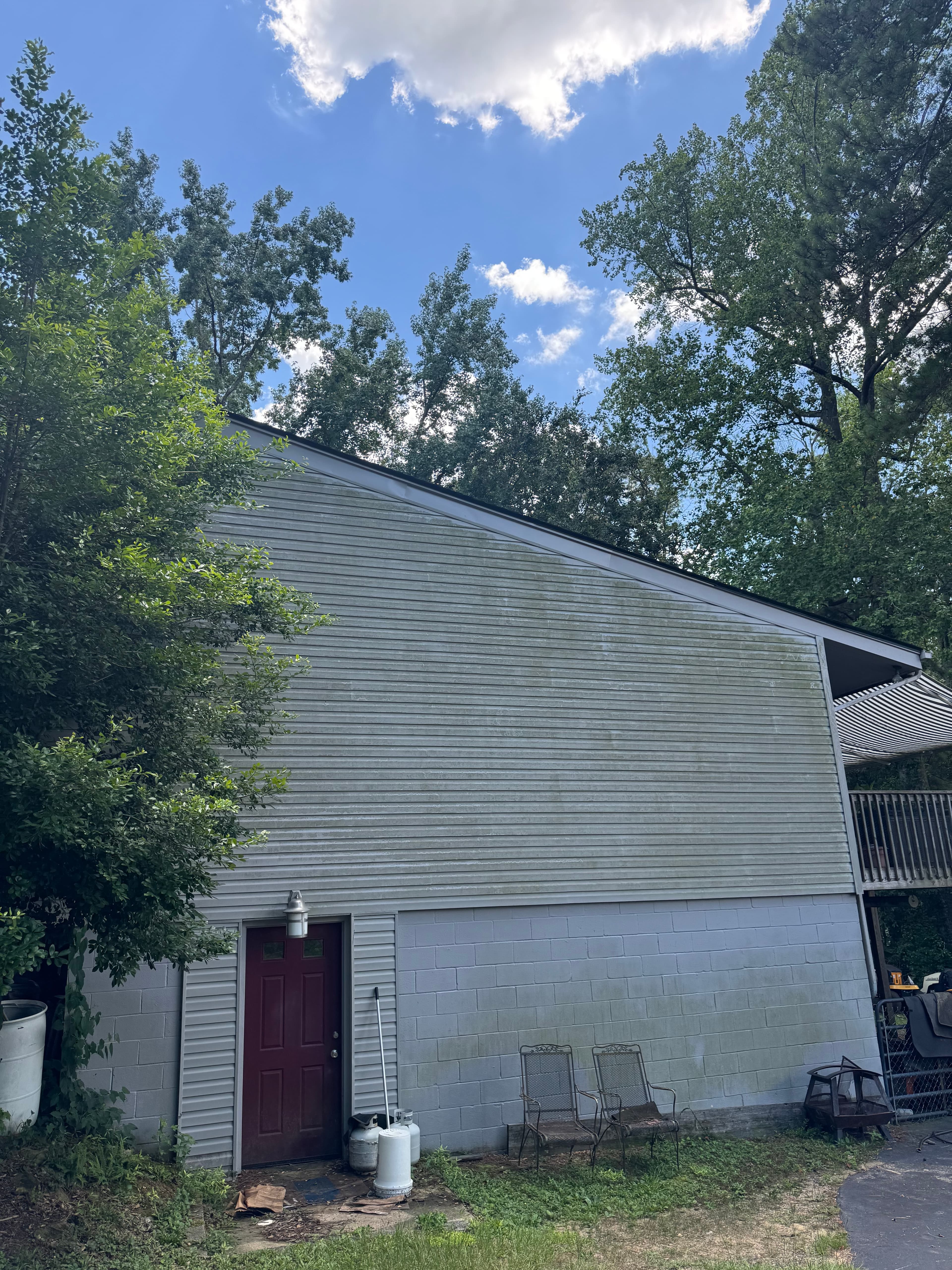 Home exterior with vinyl and brick siding covered in algae and mildew before washing in Fayetteville NC